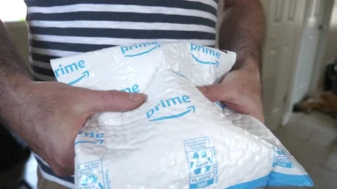 Man Holding an Amazon Prime Package That Has Been Delivered Stock Footage 133195145