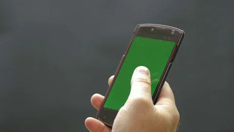 Man holding and using green screen smartphone. Black background Stock Footage 78532047