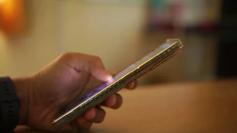 Man holding and using illuminated smartphone in dark room, social media concept Video stock 322116125