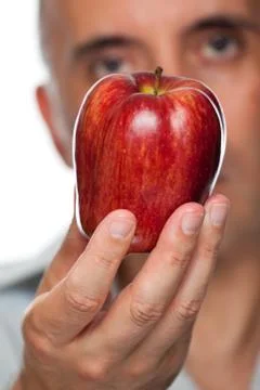 Man holding apple up close Stock Photos