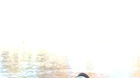 Man holding arm around woman while they listening to music by the lake Stock Footage 59555885