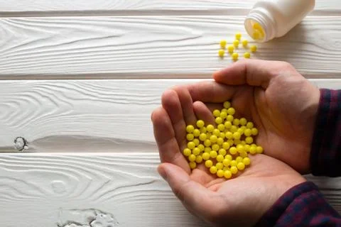 Man holding ascorbic acid in the palms Photos