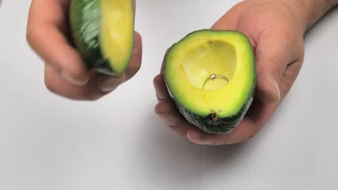 Man Holding Avocado With Engagement Ring to Propose Marriage Video stock 223383708