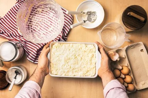 Man holding baking dish with raw cottage cheese casserole before oven. Prep.. Photos
