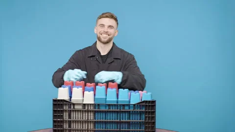 Man holding basket full of small pots for plants and puts it on the table Video stock 267903943