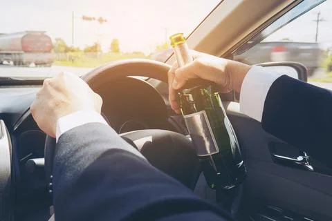 Man holding beer bottle while driving a car Stock Photos
