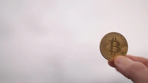 Man holding bitcoin BTC mining with wind turbine in the distance, green energy Stock Footage 85721167