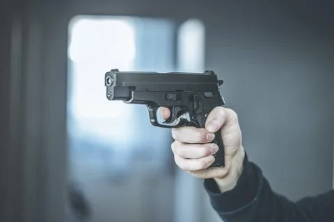 Man is holding a black fire weapon, closeup Stock Photos