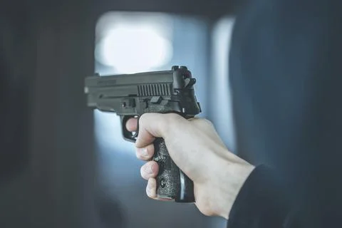 Man is holding a black fire weapon, closeup Stock Photos
