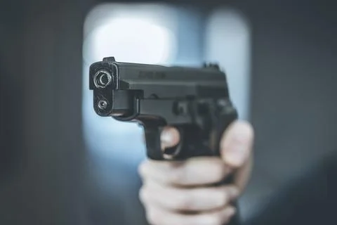 Man is holding a black fire weapon, closeup Stock Photos