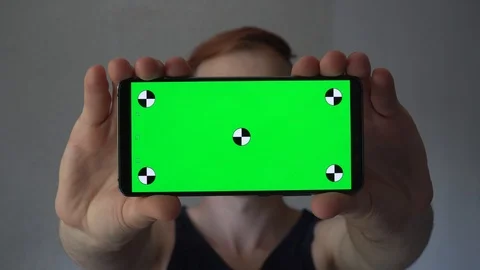 Man holding a black smartphone vertically in front of him.  Mockup template Vidéo 112990819