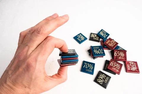 Man holding box of chocolate bars with 65, 70, and 80 percent cocoa content Foto stock