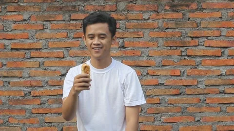 Man holding bread showing hungry expression Stock Footage 312081383