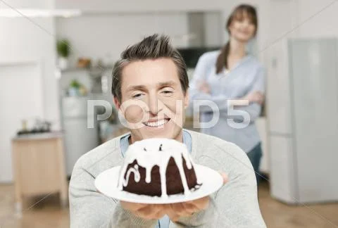 Man holding cake in domestic kitchen Stock Photos