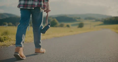 Man Holding Camera While Walking On Road Stock Footage 251992835