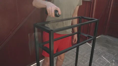 A man holding a can of black paint in his hand Vidéo 145182653