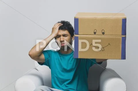 Man holding a cardboard box and looking sad Stock Photos