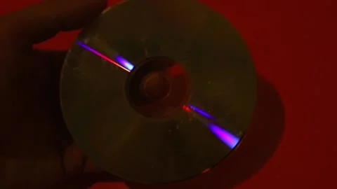 Man holding CD-ROM on a red background. Stock Footage 166926132