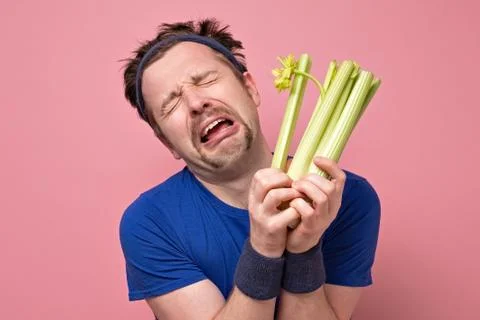Man holding celery crying. I hate vegetables but should eat for healthy diet. Stock Photos