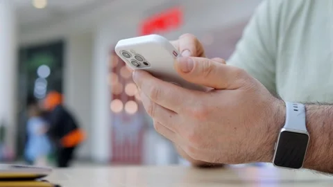 Man is holding a cell phone and wearing a smart watch Stock Footage 310224611
