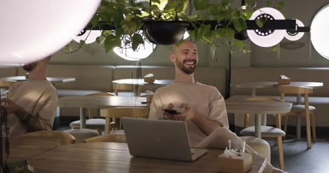 Man holding cell phone while sitting at cafe with laptop Stock Footage 159082662