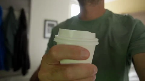 Man Holding Coffee Cup While Walking Indoors with Background Motion Stock Footage 341330041