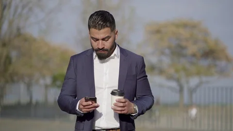 Man holding coffee to go and using cell phone outdoor Stock Footage 106938387
