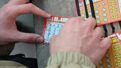 Man holding coin and scratching lottery ticket. Scratch Stock Footage 292668850