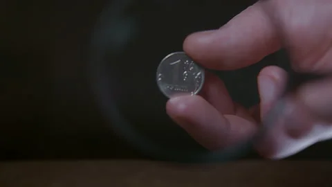 A man holding a coin, through a magnifying glass Stock Footage 225527288