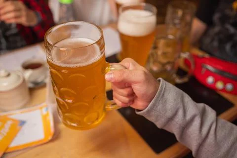 Man Holding Cold Beer Glass with his hand. Refresment Cold Lager Beer. Stock Photos