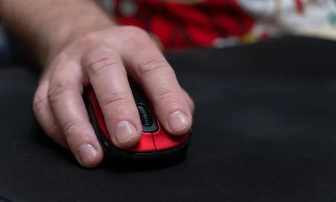 Man holding a computer mouse on a black rug Stock Photos