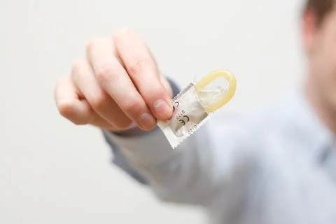 Man holding condom Stock Photos