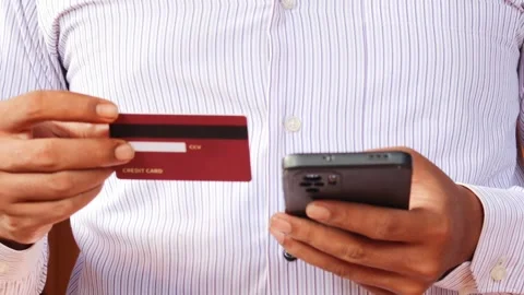 Man holding a credit card while using a smartphone 動画素材 337694782