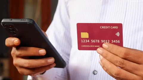 Man holding a credit card while using a smartphone Stock Footage 337694811