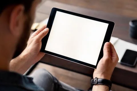 Man holding digital tablet device white screen in hand view over shoulder Stock Photos