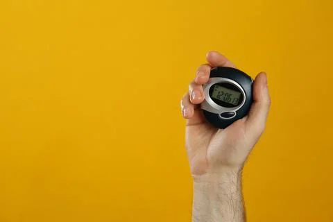 Man holding digital timer on yellow background, closeup. Space for text Stock Photos