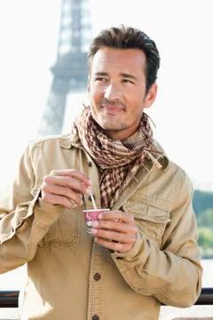 Man holding a disposable cup with the Eiffel Tower in the background, Paris, Stock-Fotos