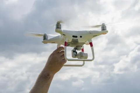 A man holding a drone on the background of cloudy sky Фото