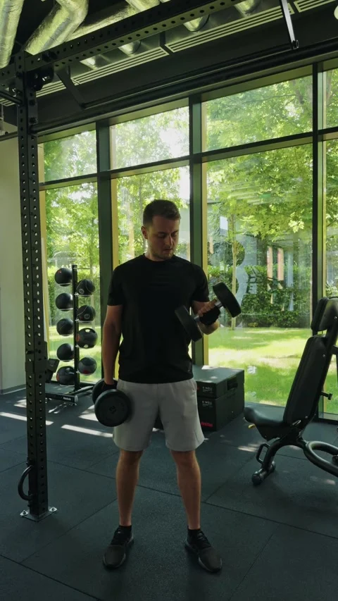 Man holding dumbbells for strength training, focusing on fitness and body care Stock-Footage 339600615
