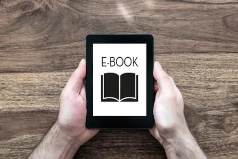 Man holding e-book reader on rustic wooden table Stock Photos