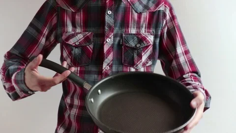 Man holding an empty cooking pan Stock Footage 100428047