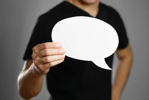 Man holding an empty speech bubble. Close up. Isolated on grey background. Stock-Fotos