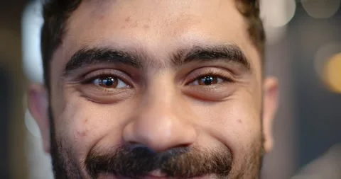 Man holding eye contact with camera, blinking and gradually smiling for studio Stock Footage 339253127