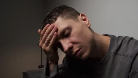 Man holding forehead headache stress relief close up minimal gray background Video stock 316053448