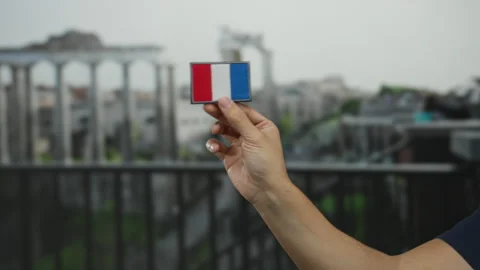 Man holding a french flag patch with ancient roman ruins in the background .. Stock Footage 314291405