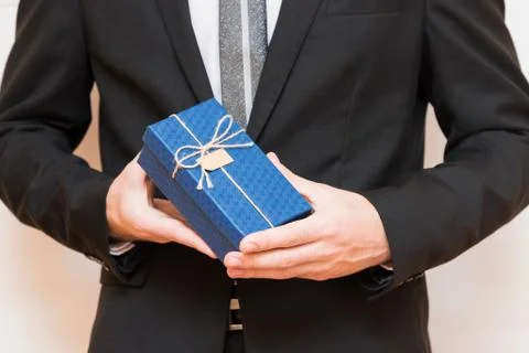 A man holding a gift box in his hands Stock Photos