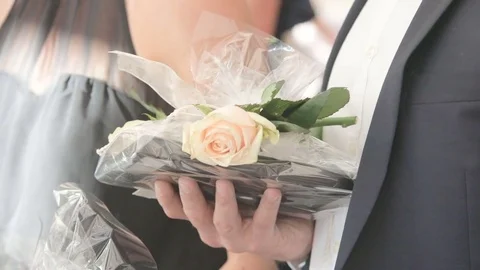 Man is holding a gift with the flower. Video stock 72379171
