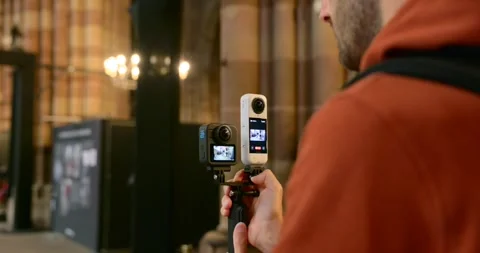 Man Holding GoPro MAX 2 and Insta360 Camera for Video Recording Vlogging Video stock 324800530