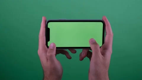 Man holding green screen phone playing game Stock Footage 236375081