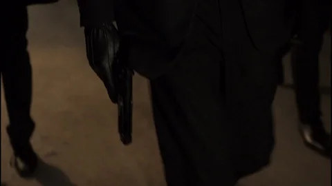 Man holding gun while walking with a group down alley at night Stock Footage 85572768